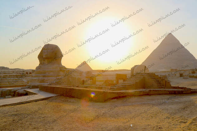 Sphinx at sunset and pyramids