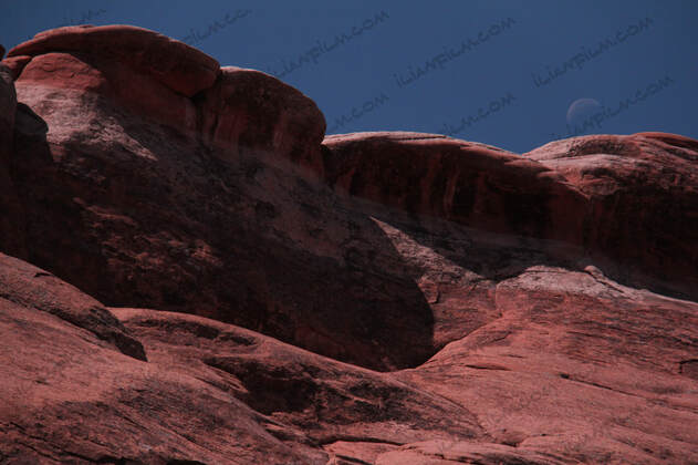 Moon above rock formation in Arches national park
