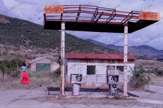 abandoned gas station and woman in red